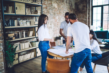 Happy young teammates chatting during work in office