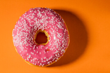 Fototapeta na wymiar Close up view of donut isolated on orange background. Food and drink concept.