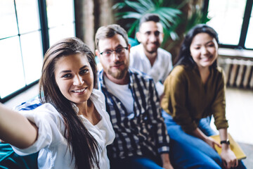 Smiling diverse colleagues taking selfie