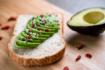 Sliced avocado on toast bread with spices, close-up