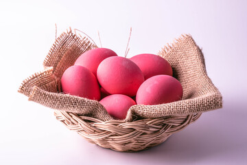 Pink century eggs in a wicker basket on a white background