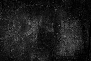 Cement old wall plaster in black and gray with a damaged surface covered with scratches, cracks and grains.