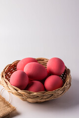 Pink century eggs in a wicker basket on a white background