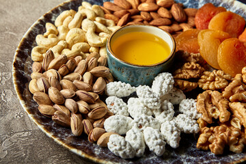 Assorted nuts and dried fruits in oriental style on a platter - dried apricots, cashews, pistachios, almonds, and walnuts