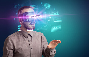 Businessman looking through Virtual Reality glasses with STRATEGY inscription, new business concept