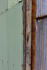 Details of parts of an old shed, weathered wooden plank, rusty metal and corrugated iron sheet