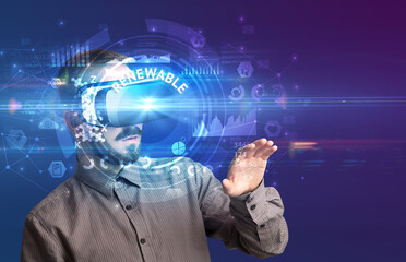 Businessman looking through Virtual Reality glasses with RENEWABLE inscription, innovative technology concept