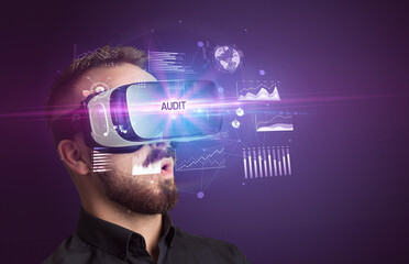 Businessman looking through Virtual Reality glasses with AUDIT inscription, new business concept