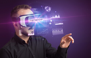 Businessman looking through Virtual Reality glasses with PARTNERSHIP inscription, new business concept