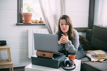 Woman works with laptop at home in the living room