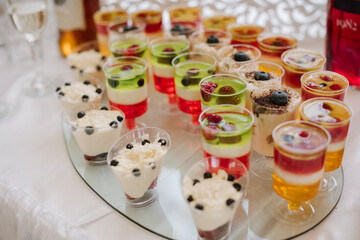 Sweet dessert cakes and cupcakes and jellys on the candy bar at the celebration