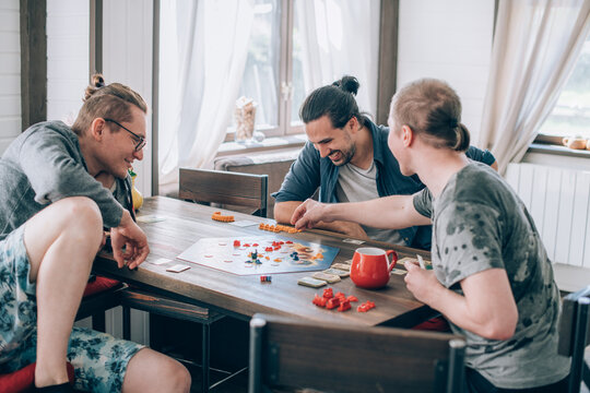 Friends Play A Board Game In The Living Room