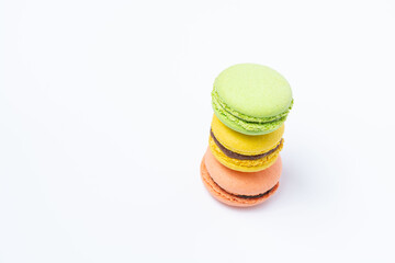 Macaroni of red, yellow and green color are stacked one on top of the other in the form of a tower on a white background