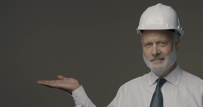 Smiling engineer presenting something to the camera