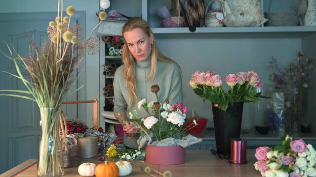 Woman florist creating beautiful bouquet in flower shop. Work in flower shop. Flowers delivery.