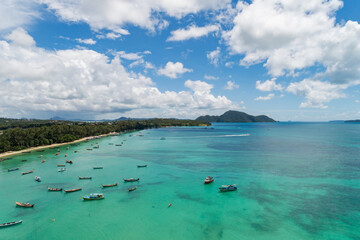 Aerial View Drone shot of Thai traditional longtail fishing boats in the tropical sea beautiful beach in phuket thailand.