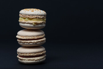 White macaroni are stacked one on top of the other in the form of a tower on a black background. Side view
