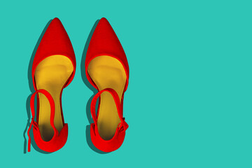 Red women's shoes on a turquoise background with a copy of the space. Fashionable women's colored background. A top view of a flat layout. Fashion blog