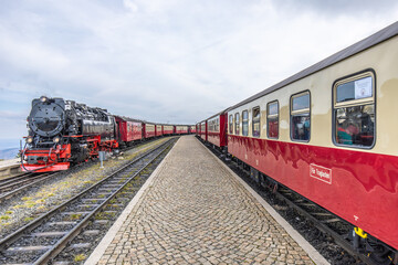 Fototapeta na wymiar Dampflock, Dampflokomotive am Bahnsteig mit Wagnons und Schienen