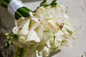 Beautiful wedding bouquet and rings on wedding day