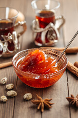 Quince jam in a glass bowl on wooden background
