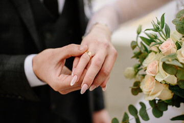 Bride and groom put each other ring on the finger