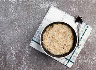 Oatmeal in a bowl on a dark background. Top view, flat lay