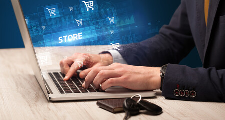 Obraz na płótnie Canvas Businessman working on laptop with STORE inscription, online shopping concept