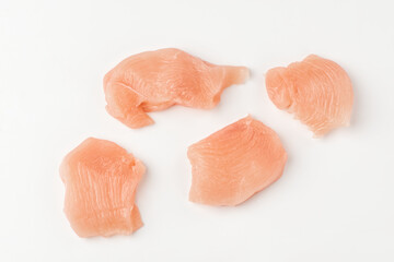 Top view on pieces of raw chicken fillet on white background