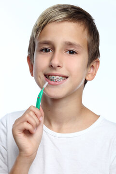 Boy with braces smiling while brushing your teeth