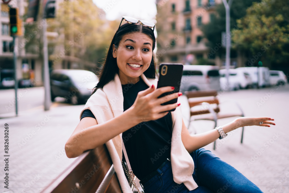 Poster amazed asian hipster girl surprised with get discount in web store browse on smartphone outdoors, sm