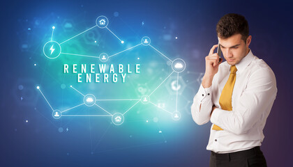 Businessman in front of cloud service icons with RENEWABLE ENERGY inscription, modern technology concept