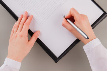 Close up business woman signing business papers. Hands of female executive signing a business...