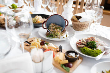 Table setting on which there is a cheese plate Russian salad and a meat plate
