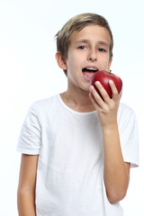 Young boy eating a red apple on a white background