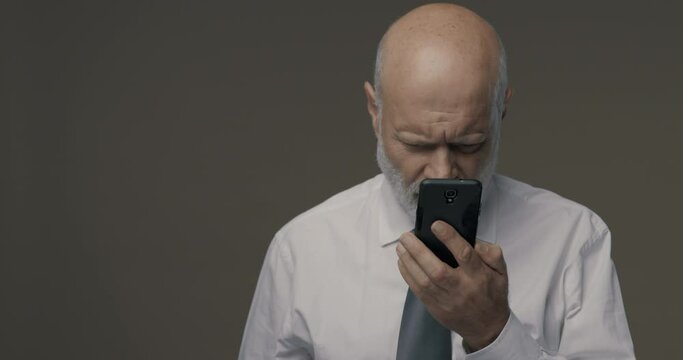 Middle-aged man having difficulties and vision problems using his smartphone