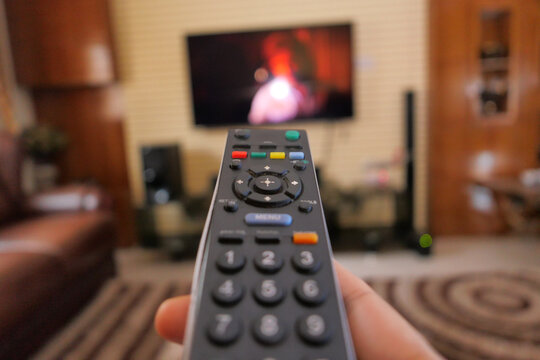 close up of women hand holding tv remote.