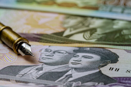 Various banknotes of North Korean won KPW , currency over pen for writing