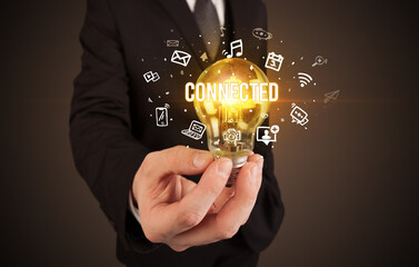 Businessman holding light bulb with CONNECTED inscription, social media concept