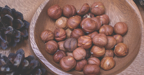 Hazelnuts in a wooden bowl. Autumn background.
