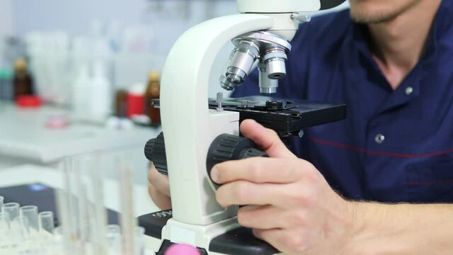 Scientist prepare blood sample for research on microscope. Placing blood sample on microscope slide