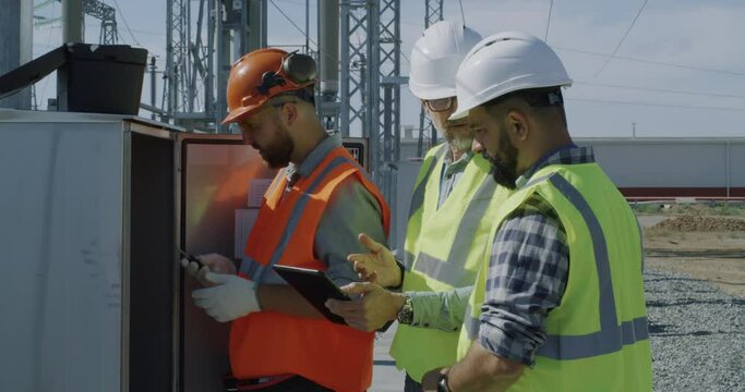 Engineers fixing transformer during inspection