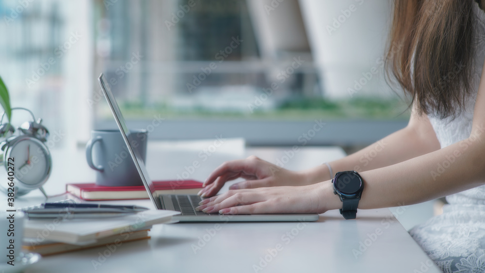 Poster side view of college girl working on their assignment with laptop and tablet a in a comfortable work