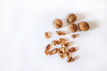 Fototapeta na wymiar Nuts on a white background. Walnuts. Walnut and cracked walnut. Fresh walnuts. Walnuts for sale in the market. Natural nuts. Chopped walnuts. Creative walnut mockup. Isolated nuts. Nuts background. 
