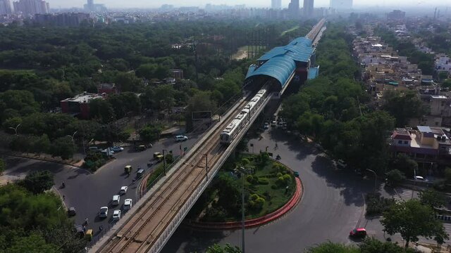 An aerial shot of the Delhi metro leaving the station in New Delhi, India
