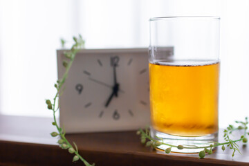 朝目覚まし時計を見て一杯のお茶を飲むモーニングルーティーン