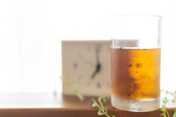 朝目覚まし時計を見て一杯のお茶を飲むモーニングルーティーン
