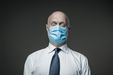 Worried businessman wearing a surgical mask