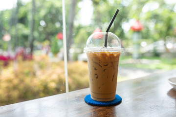 Ice Americano coffee (Very Popular coffee in Thailand on) wooden with natural blurred background.