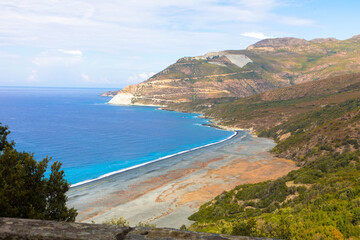 Luftaufnahme des schwarzen Kieselstrandes, Nonza, mediterranes Gestrüpp, küstennahe Hänge. Cap Corse, Korsika, Frankreich